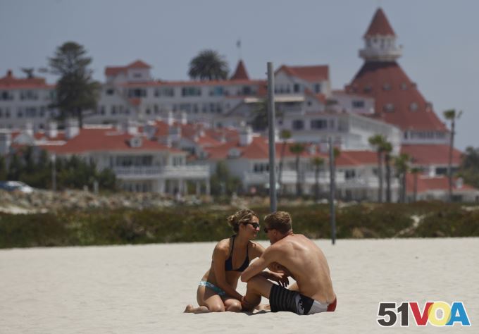 In this May 22, 2012 photo, a couple enjoys the sun and sand on Coronado Beach in California.