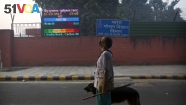 An Indian looks at the air quality level board outside India Meteorological Department, which shows condition of air as severe post during Diwali festival, in New Delhi, Oct. 20, 2017.