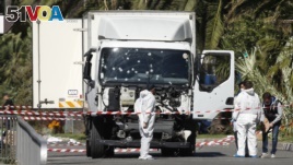 Investigators near the heavy truck that ran into a crowd at high speed, killing 84 people who were celebrating the Bastille Day, July 14 national holiday on the Promenade des Anglais in Nice, France, July 15, 2016. 