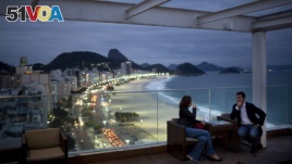 FILE - Tourists sit in a bar at a hotel overlooking Copacabana beach, in Rio de Janeiro, Brazil, Aug. 16, 2013.