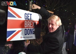 Britain's Prime Minister and Conservative party leader Boris Johnson poses as he hammers a 