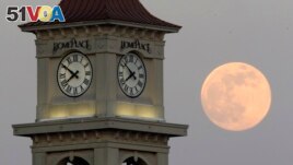 FILE - The moon rises behind the Home Place clock tower in Prattville, Ala., Saturday, June 22, 2013. (AP Photo/Dave Martin, File)