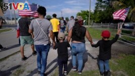 FILE - Carrying American flags, immigrants march during a peaceful protest against a Florida legislation restricting undocumented immigrants, Thursday, June 1, 2023, in Immokalee, Florida. (AP Photo/Rebecca Blackwell)