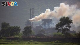 FILE - Smoke rises from a coal-powered steel plant at Hehal village near Ranchi, in eastern state of Jharkhand, Sept. 26, 2021. (AP Photo/Altaf Qadri, File)