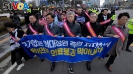 Doctors march toward the presidential office during a rally against the government's medical policy in Seoul, South Korea, Sunday, Feb. 25, 2024. (AP Photo/Ahn Young-joon)