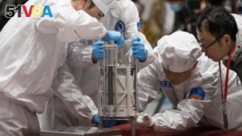 FILE - In this Thursday, Dec. 17, 2020 photo provided by China's Xinhua News Agency, technicians prepare to weigh a container carrying moon samples retrieved by China's Chang'e 5 lunar lander in Beijing. (Jin Liwang/Xinhua via AP, File)