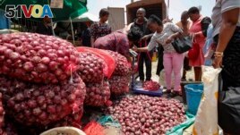People buy onions at an open market in Nairobi, Kenya Tuesday, Sept. 12, 2023. (AP Photo/Brian Inganga)