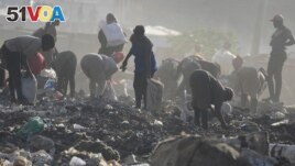 People look for recyclable materials for a living, at Dandora, the largest garbage dump in the capital Nairobi, Kenya Wednesday, March 20, 2024. U.N. agencies have warned that electrical and electronic waste is piling up worldwide. (AP Photo/Brian Inganga)