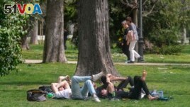 FILE - People relax in the Retiro park in Madrid, Spain, March 20, 2024. Earth just had its warmest March ever recorded, according to the European Union climate agency Copernicus. (AP Photo/Paul White, File)