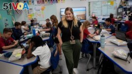 Third grade teacher Megan Foster walks through her classroom as students take a break from a reading lesson, Tuesday, April 16, 2024. (AP Photo/Rebecca Blackwell)