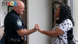 Knoxville Deputy Police Chief Tony Willis talks with Terry Walker-Smith after a meeting of the Violence Reduction Leadership Committee on Thursday, Aug. 3, 2023, in Knoxville, Tenn. (AP Photo/George Walker IV)
