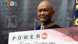 Cheng Charlie Saephan holds display check during a news conference where it was revealed that he was one of the winners of the $1.3 billion Powerball jackpot at the Oregon Lottery headquarters, April 29, 2024, in Salem, Ore. (AP Photo/Jenny Kane)