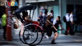 Rickshaw puller Akina Suzuki, 19, drives a rickshaw around Asakusa district in Tokyo, Japan, June 18, 2023. (REUTERS/Issei Kato)