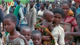 FILE — Hutu refugees women and children wait to be registered at Kigali airport Rwanda, after they arrived on the UN plane from Kisangai, Zaire Sunday, May 4, 1997. (AP Photo/Sayyid Azim, File)