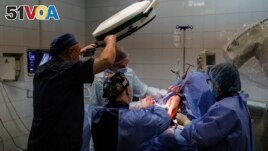 Petro Nikitin, left, takes part a surgery operation of Ukrainian serviceman at the military hospital in Kyiv, Ukraine, on Thursday, May 5, 2023. (AP Photo/Alex Babenko)
