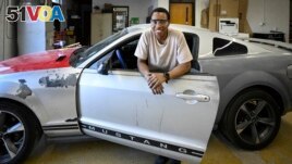 Tennessee College of Applied Technology Nashville student Robert Nivyayo poses with his car during auto collision repair class Wednesday, April 13, 2023. (AP Photo/John Amis)