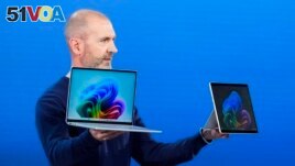 Brett Ostrum, Microsoft corporate vice president of Surface, holds up the new Surface Laptop and Surface Pro with built-in AI at an event of the company's AI assistant, Copilot, Monday, May 20, 2024, in Redmond, Wash. (AP Photo/Lindsey Wasson)