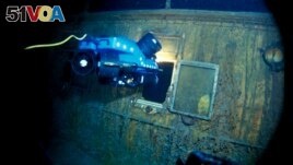 In this image from the Woods Hole Oceanographic Institution, an underwater remote vehicle examines an open window of the Titanic in 1986.