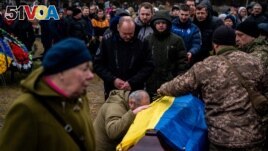 People attend a funeral ceremony for Ukrainian serviceman Yurii Kulyk, 27, killed in Donetsk region, in Kalynivka, near Kyiv, on February 21, 2023, amid the Russian invasion of Ukraine. (Photo by Dimitar DILKOFF / AFP)