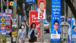 FILE - People walk past electoral campaign posters as Thailand will hold general elections on May 14, in Bangkok, Thailand, April 26, 2023. (REUTERS/Chalinee Thirasupa/File Photo)