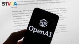 The OpenAI logo is seen on a mobile phone in front of a computer screen displaying output from ChatGPT, March 21, 2023, in Boston. (AP Photo/Michael Dwyer, File)