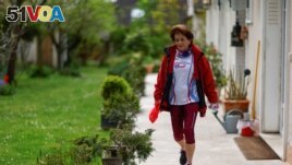 Barbara Humbert, 83, long-distance world record winner in her category who dreams to run the Olympic Marathon For All at the Paris 2024 Olympics and Paralympics Games, walks in the garden of her house in Eaubonne near Paris, France April 26, 2023. (REUTERS/Gonzalo Fuentes)