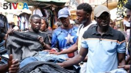Ugandans buy used clothes at Owino Market, in Kampala, Uganda, Sept. 15, 2023. (AP Photo/Hajarah Nalwadda)