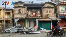 A local rides motorbike past damaged buildings after Cyclone Mocha in Sittwe township, Rakhine State, Myanmar, Monday, May 15, 2023. (AP Photo, File)
