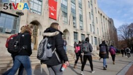 FILE - Students walk past an entrance to Boston University College of Arts and Sciences in Boston, Nov. 29, 2018. (AP Photo/Steven Senne, File)