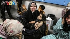 Wounded Palestinians sit in al-Shifa Hospital in Gaza City, central Gaza Strip, after arriving from al-Ahli Hospital following an explosion there, Oct. 17, 2023. (AP Photo/Abed Khaled, File)