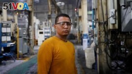 Walter Banegas, 28, originally from Honduras, poses for a picture during his shift at the Pace Industries aluminum injection molding plant, his formal job after settling in Mexico as a refugee, in Saltillo, Mexico October 16, 2023. (REUTERS/Daniel Becerril)