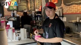 Christopher Au, 19, dishes out ice cream at a J.P. Licks in Boston's Beacon Hill neighborhood on Thrusday, May 25, 2023. (AP Photo/Steve LeBlanc)