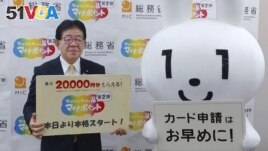 Japan's Minister of Internal Affairs and Communications Yasushi Kaneko promoting My Number cards on June 30, 2022. (Kyodo News via AP)