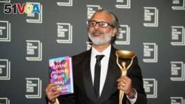 Writer Shehan Karunatilaka holds the Booker Prize after the announcement of the honor for his novel, The Seven Moons of Maali Almeida in London, Oct. 17, 2022. (AP Photo/Alberto Pezzali)