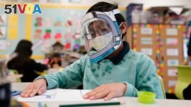 FILE - A student wears a mask and face shield in a 4th grade class amid the COVID-19 pandemic at Washington Elementary School on Jan. 12, 2022. (AP Photo/Marcio Jose Sanchez, File)