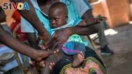 A baby from the Malawi village of Tomali is injected with the world's first vaccine against malaria in a pilot program, in Tomali, Dec. 11, 2019. (AP Photo/Jerome Delay, File)