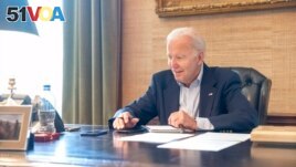 In this image provided by the White House, President Joe Biden speaks on the phone from the Treaty Room in the residence of the White House, July 21, 2022. Biden says he's doing great after testing positive for COVID-19. 