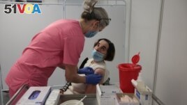 A woman receives a vaccination against the coronavirus disease (COVID-19) at a temporary vaccination centre in Kielce, Poland, January 25, 2021. (Pawel Malecki/Agencja Gazeta via REUTERS)