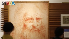 Visitors look at a portrait drawing of Italian Renaissance painter, scientist and inventor Leonardo Da Vinci in Rome, May 2, 2019. Leonardo died 500 years ago in Amboise, France, on May 2, 1519. (AP Photo/Alessandra Tarantino)