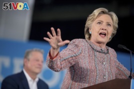 Democratic presidential candidate Hillary Clinton, accompanied by former Vice President Al Gore, left, speaks at a rally at Miami Dade College in Miami, Oct. 11, 2016.