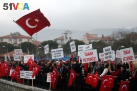 Supporters of President Tayyip Erdogan wave Turkish flags during the first hearing of the trial for soldiers accused of attempting to assassinate Erdogan during last year's failed July 15 coup, in Mugla, Turkey, Feb. 20, 2017.