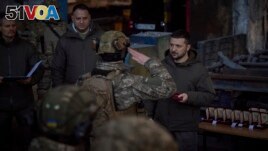 FILE - In this photo provided by the Ukrainian Presidential Press Office, Ukrainian President Volodymyr Zelenskyy, right, awards a serviceman at the site of the heaviest battles with the Russian invaders in Bakhmut, Ukraine, Tuesday, Dec. 20, 2022. 