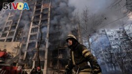 A firefighter walks outside a destroyed apartment building after a bombing in a residential area in Kyiv, Ukraine, March 15, 2022. (AP Photo/Vadim Ghirda)