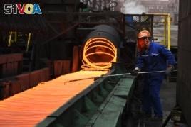 A Chinese employee sorts hot red steel at a steel plant in Zouping in China's eastern Shandong province on March 5, 2018.