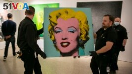 The 1964 silk-screen image, Shot Sage Blue Marilyn, by Andy Warhol is carried in Christie's showroom in New York, Sunday, May 8, 2022. The image sold for $195 million, Monday, May 9. (AP Photo/Ted Shaffrey, File)
