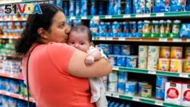Yury Navas, 29, of Laurel, Md., kisses her two-month-old baby Jose Ismael G<I>&#</i>225;lvez, while looking for formula at Superbest International Market in Laurel, Md., May 23, 2022. (AP Photo/Jacquelyn Martin)