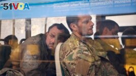 Ukrainian servicemen sit in a bus after they were evacuated from the besieged Mariupol Azovstal steel plant, near a remand prison in Olyonivka, in territory under the government of the Donetsk People's Republic, eastern Ukraine, May 17, 2022. (AP Photo/Alexei Alexandrov)