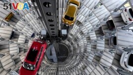 This file photo shows cars ready for delivery at a 'car tower' at the Volkswagen vehicle factory in Wolfsburg, Germany, Monday, Nov. 8, 2021. (AP Photo/Michael Sohn, file)