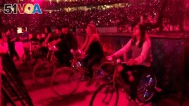 Concertgoers ride stationary bikes during Coldplay's Music of the Spheres world tour on Thursday, May 12, 2022, at State Farm Stadium in Glendale, Ariz. (Photo by Rick Scuteri/Invision/AP)