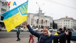 FILE - Ukrainians gather in downtown to celebrate the recapturing of their city Kherson, Ukraine, Saturday, Nov. 12, 2022. (AP Photo/Yevhenii Zavhorodnii)